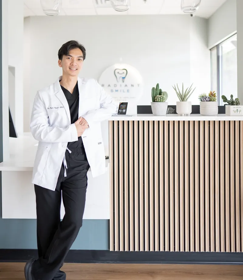 Dr. Ryan Nguyen standing at the front desk of the Radiant Smile office in Suwanee